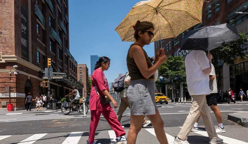 NYC-heat-wave-people-with-umbrellas_GettyImages-2284372317